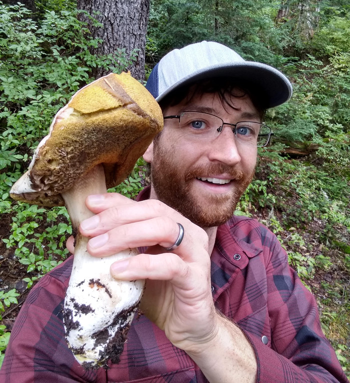 A picture of Kameron holding a large porcini mushroom